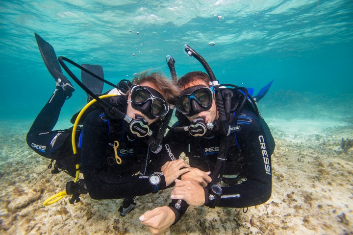 Two scuba divers smiling underwater